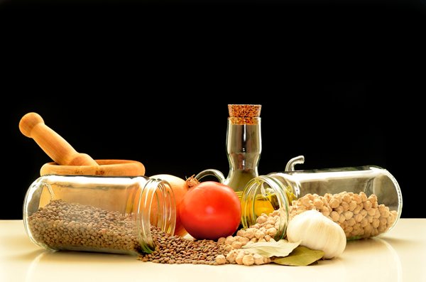 Aceite de oliva, tomate, ajo y legumbres sobre una mesa